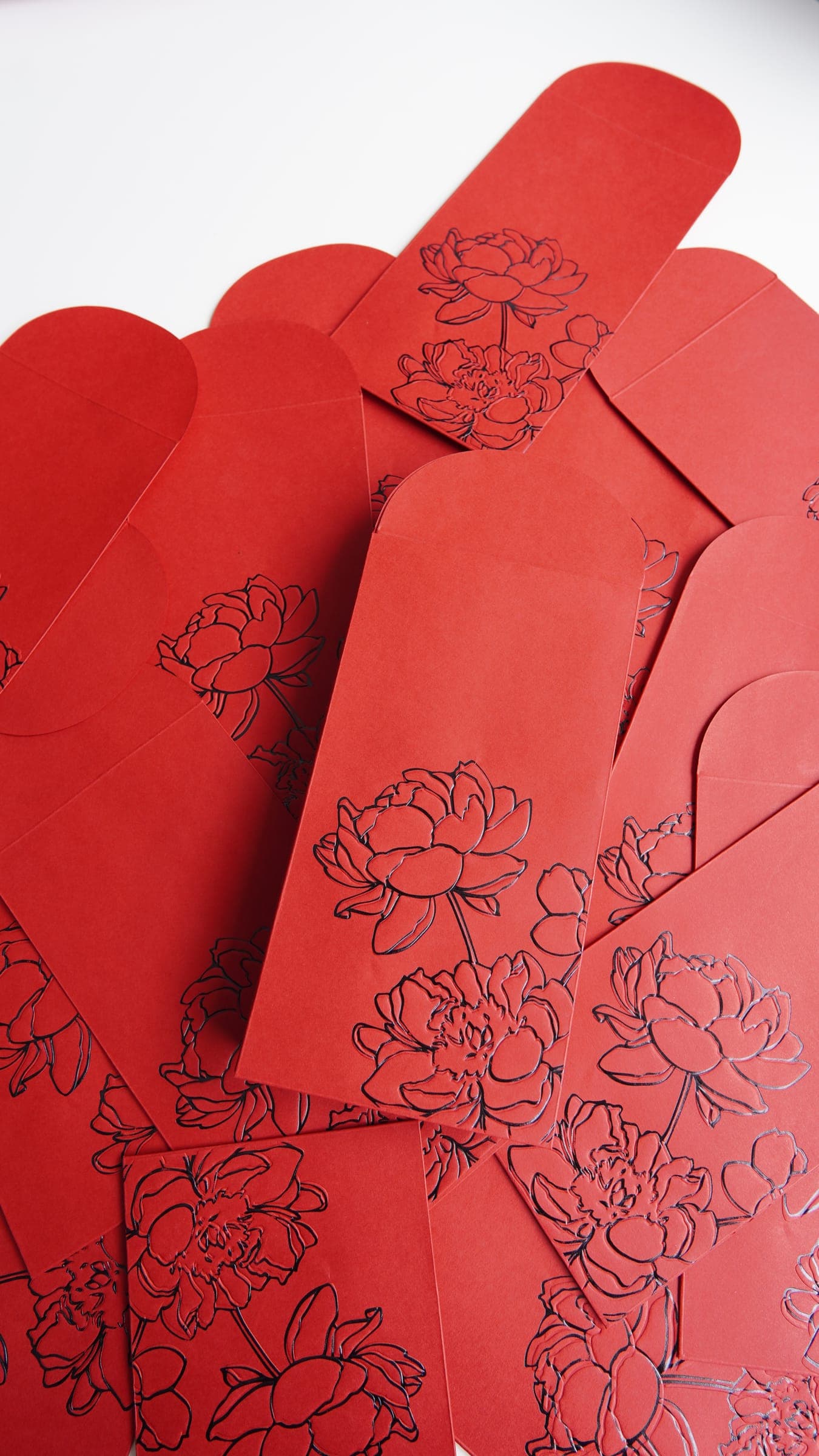 Red printed envelopes with floral line art and die-cut flaps